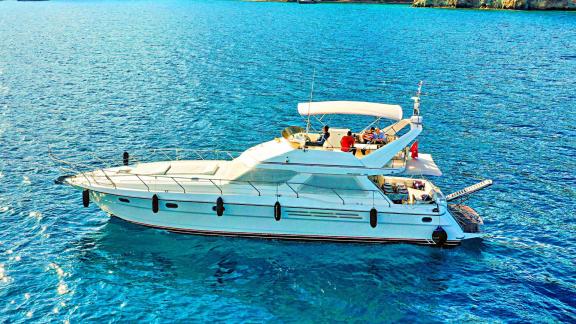 Exterior view of motor yacht Sweet Lily, guests enjoying their time on the upper deck.