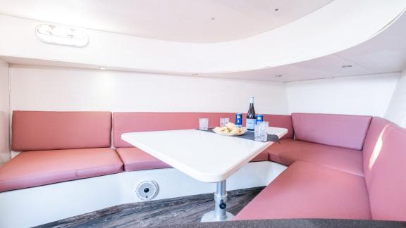 The interior dining area of the Tequila motor yacht offers comfortable seating and a table, with seafood served.