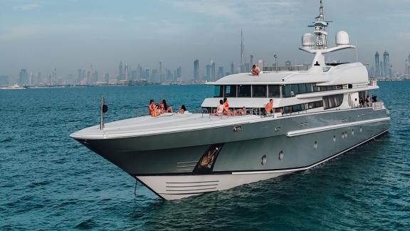 The yacht Thunder showcases elegance on open waters with a modern city skyline.