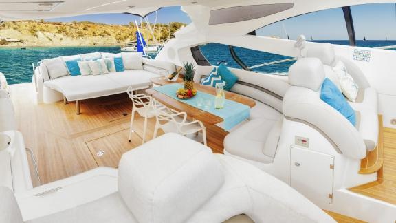 Tranquility 3 bietet auf dem offenen Deck bequeme Sofas und einen Esstisch bei Ibiza.