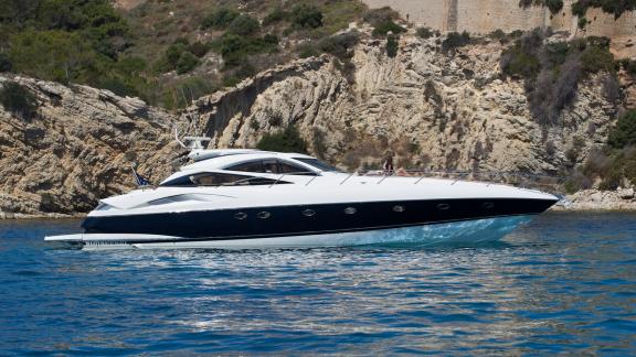 Motoryacht Tranquility 3 liegt vor Anker nahe der felsigen Uferlinie von Ibiza.