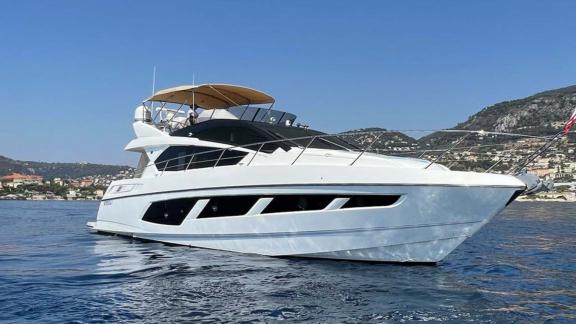 Among Nice yacht charter options Turquoise motor yacht shows bow area and flybridge while cruising.