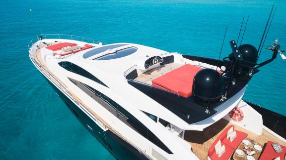 The deck of motor yacht Um7 features a spacious sunbathing area equipped with red cushions.