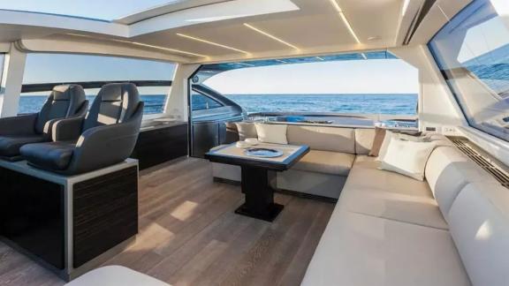 The salon of motor yacht Urus features a comfortable seating area, modern furniture, and large windows.