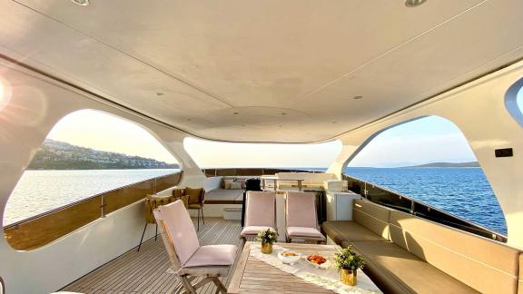 The upper deck of Vedo B yacht features a spacious seating area, comfortable chairs, and stunning sea views.