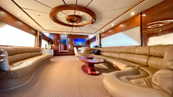 The interior of the Vedo B yacht features a spacious and luxurious living area with comfortable sofas and a large table.