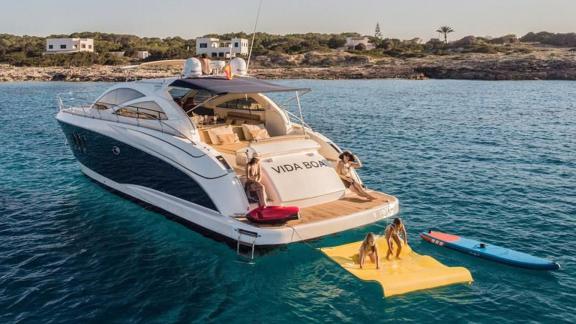 Guests are enjoying fun moments with water toys on the aft deck of motor yacht Vida Boa.