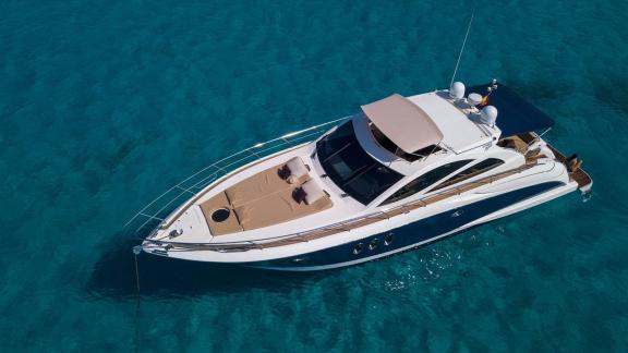 The spacious foredeck of motor yacht Vida Boa provides an ideal relaxation area on turquoise waters.