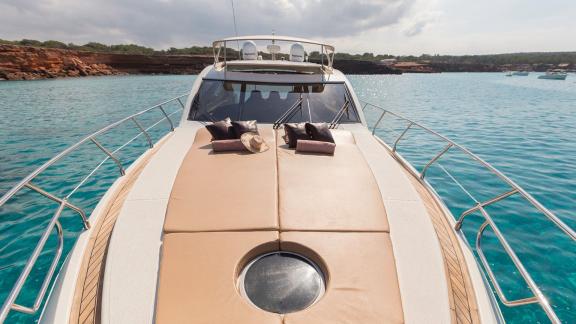 The foredeck of motor yacht Vida Boa, with comfortable cushions and a spacious sunbathing area, is perfect for relaxatio