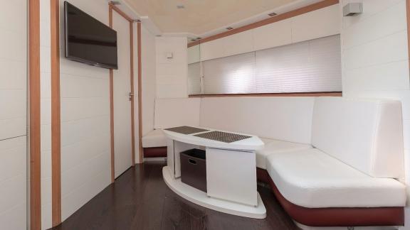 The elegant living room of motor yacht Vida Boa features a spacious seating area and a flat-screen TV for comfort.