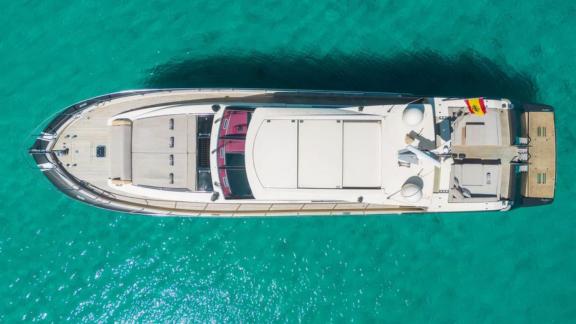 Aerial view of motor yacht Vintage anchored in turquoise waters.