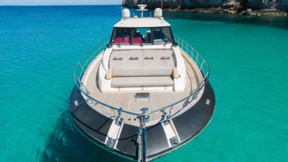 The foredeck of motor yacht Vintage features a comfortable sunbathing area surrounded by turquoise waters.