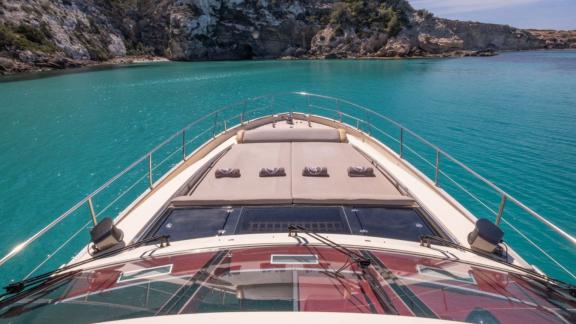 Das Vordeck der Motoryacht Vintage bietet eine großzügige Sonnenliegefläche mit Blick auf das türkisfarbene Meer.