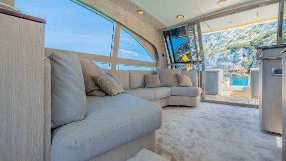 The salon of motor yacht Vintage offers a cozy seating area with access to the aft deck.