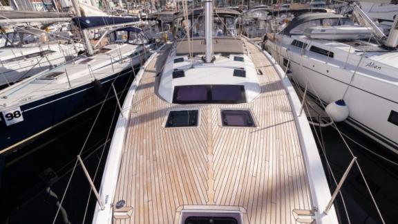 The teak foredeck of the Vita yacht anchored in the marina.