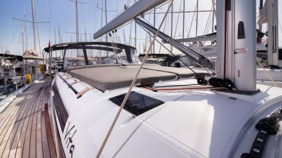 The deck of the Vita yacht, with its sailing gear and other yachts in the marina.