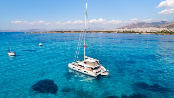 The White Caps catamaran is shown anchored peacefully in calm blue waters.