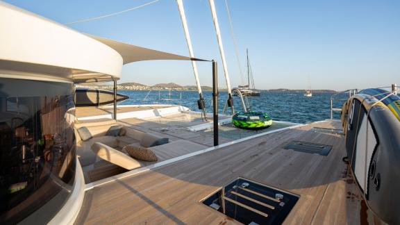 The spacious deck of White Caps catamaran offers a relaxation area with a sea view.