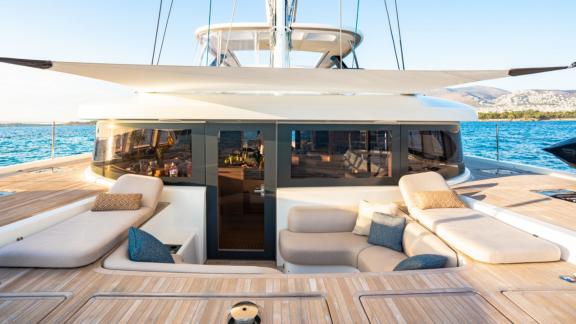 The spacious lounge area of White Caps catamaran features a sea view and comfortable cushions.