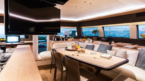 The seating area inside White Caps catamaran features large windows and comfortable chairs.