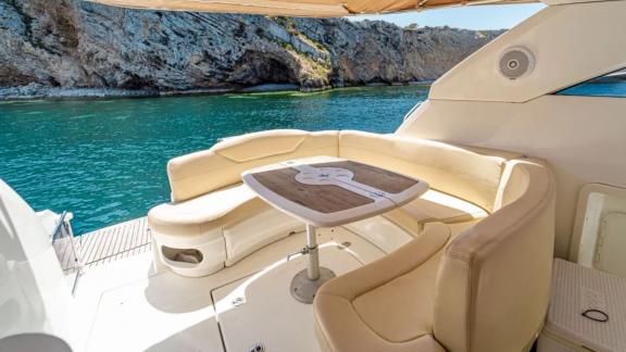 Comfortable seating area on the aft deck of motor yacht Xenia with a sea view.