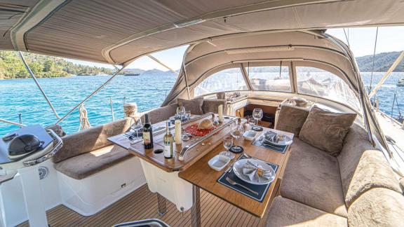 Elegant dining area on the aft deck of yacht Özgürüm in Göcek with a view of the sea.