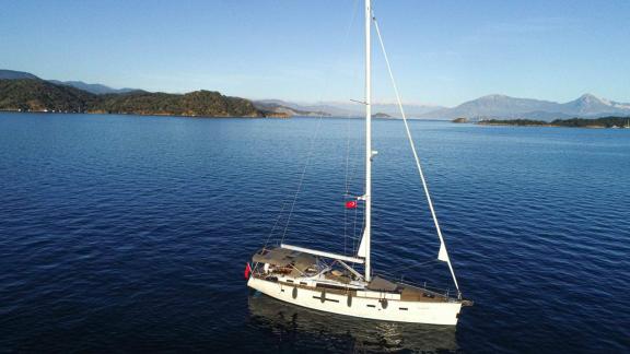 The sailing yacht Özgürüm is elegantly anchored on the calm waters of Göcek.