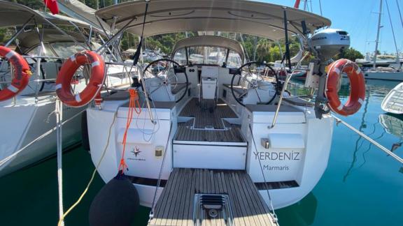 Helm area and aft deck of the Yerdeniz sailing yacht with other boats moored at the marina.