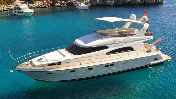 Motor yacht Zeus 1 floating in crystal clear blue waters.