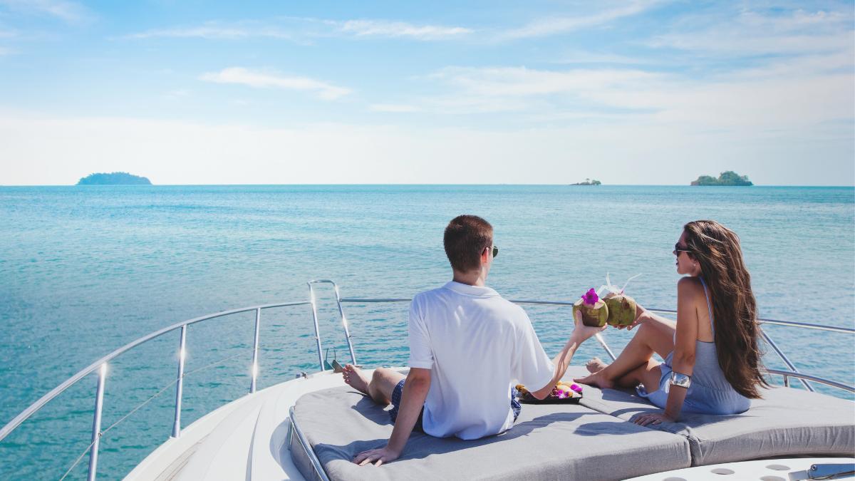 Ein Paar entspannt sich auf dem Vorderdeck einer Yacht und genießt den weiten Meerblick