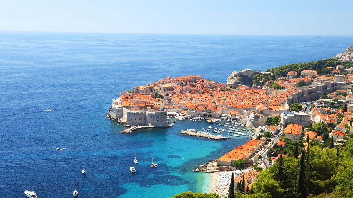 Historischer Ort in Dubrovnik mit einem Turm auf einem Berg und blauem Meer neben einer Stadt