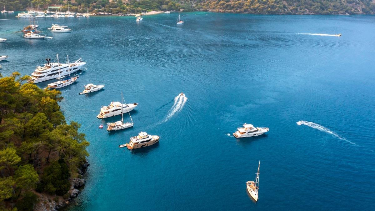 Luftaufnahme von Yachten und Booten vor Anker in einer idyllischen Bucht in Fethiye, Türkei.