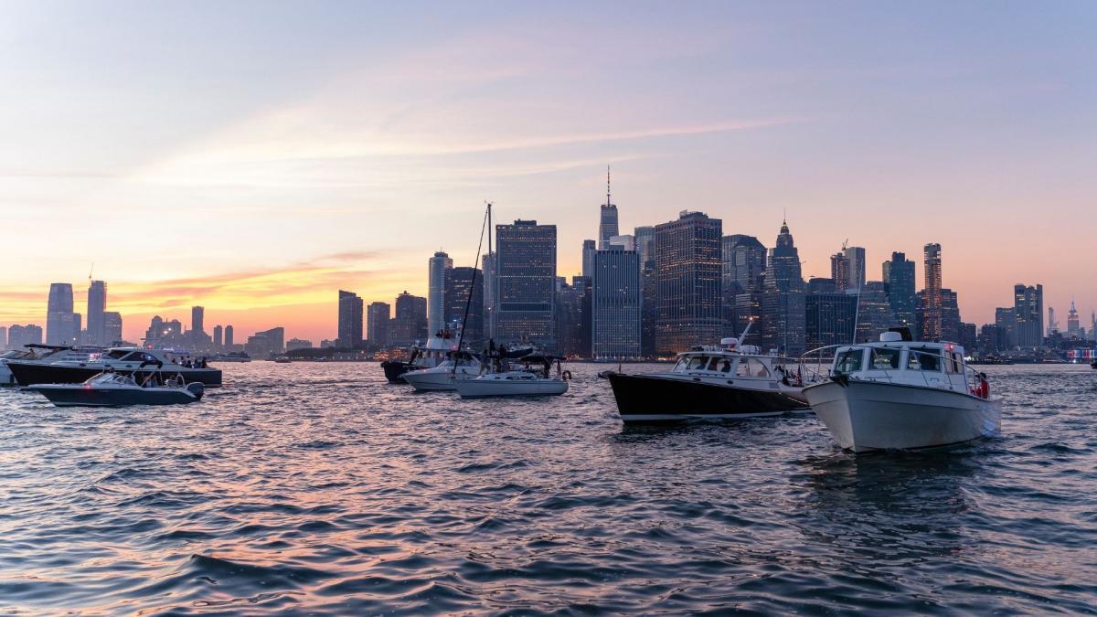 Arten von Yachten: Yachten unterschiedlicher Größe und Ausstattung segeln bei Sonnenuntergang auf dem Meer.