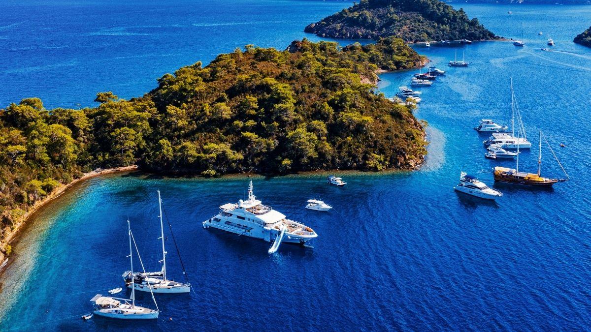 In Göcek's picturesque bay, elegant yachts anchor in deep blue waters between green hills