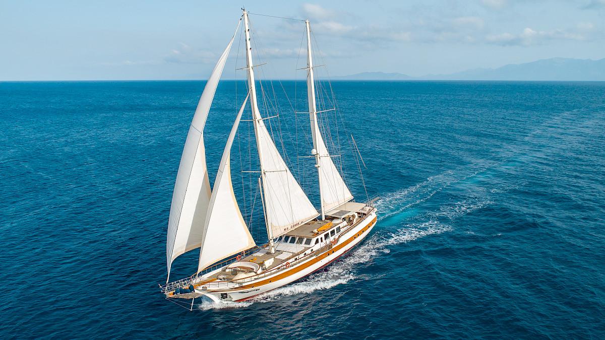 Eine majestätische Gulet-Yacht segelt mit vollen Segeln auf dem weiten, blauen Meer