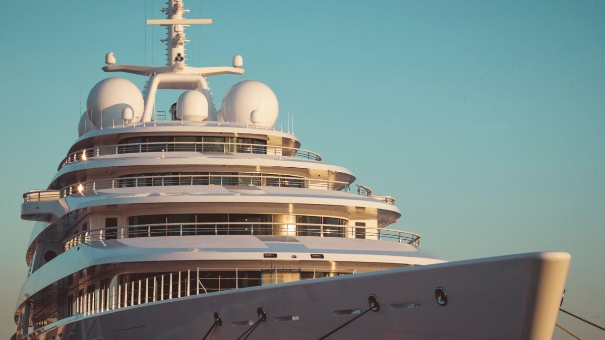 Die fertige große und weiße Luxusyacht liegt bewegungslos im Hafen