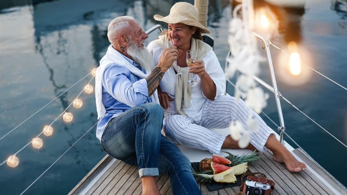 Yaşlı bir çift teknede romantik akşam yemeği eşliğinde keyifli vakit geçiriyor.