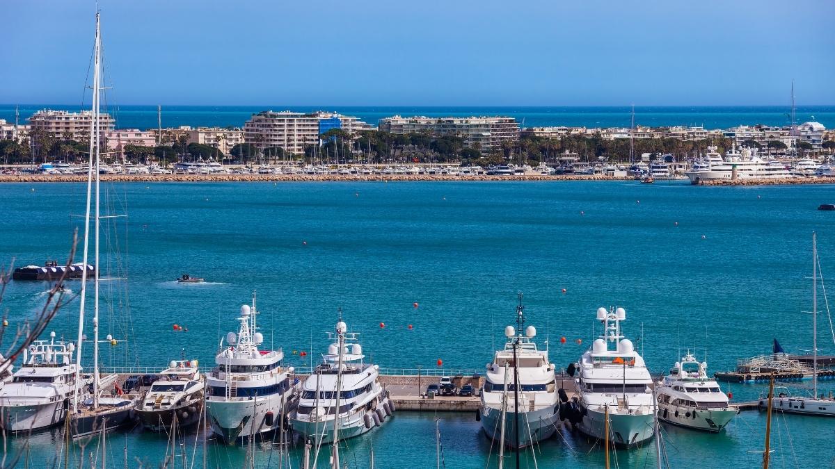 Exklusive Yachten im Hafen vor der Küste einer lebendigen Stadt, ideal für luxuriöse Kreuzfahrten.