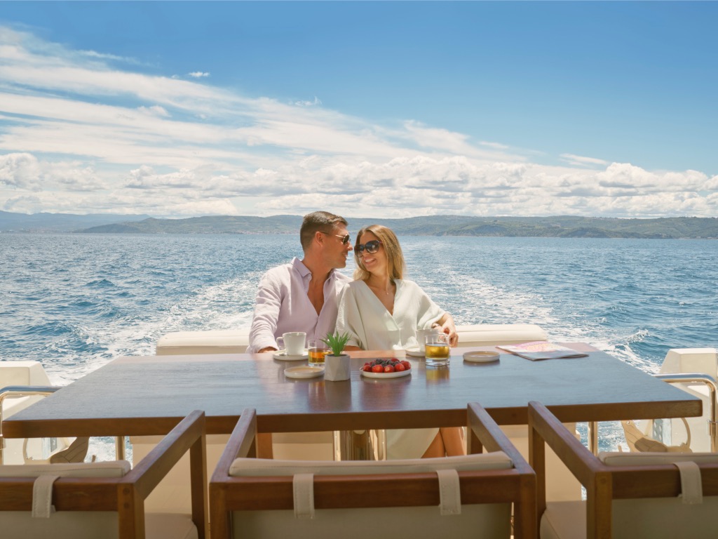 Couple drinking whisky while luxury yacht sails