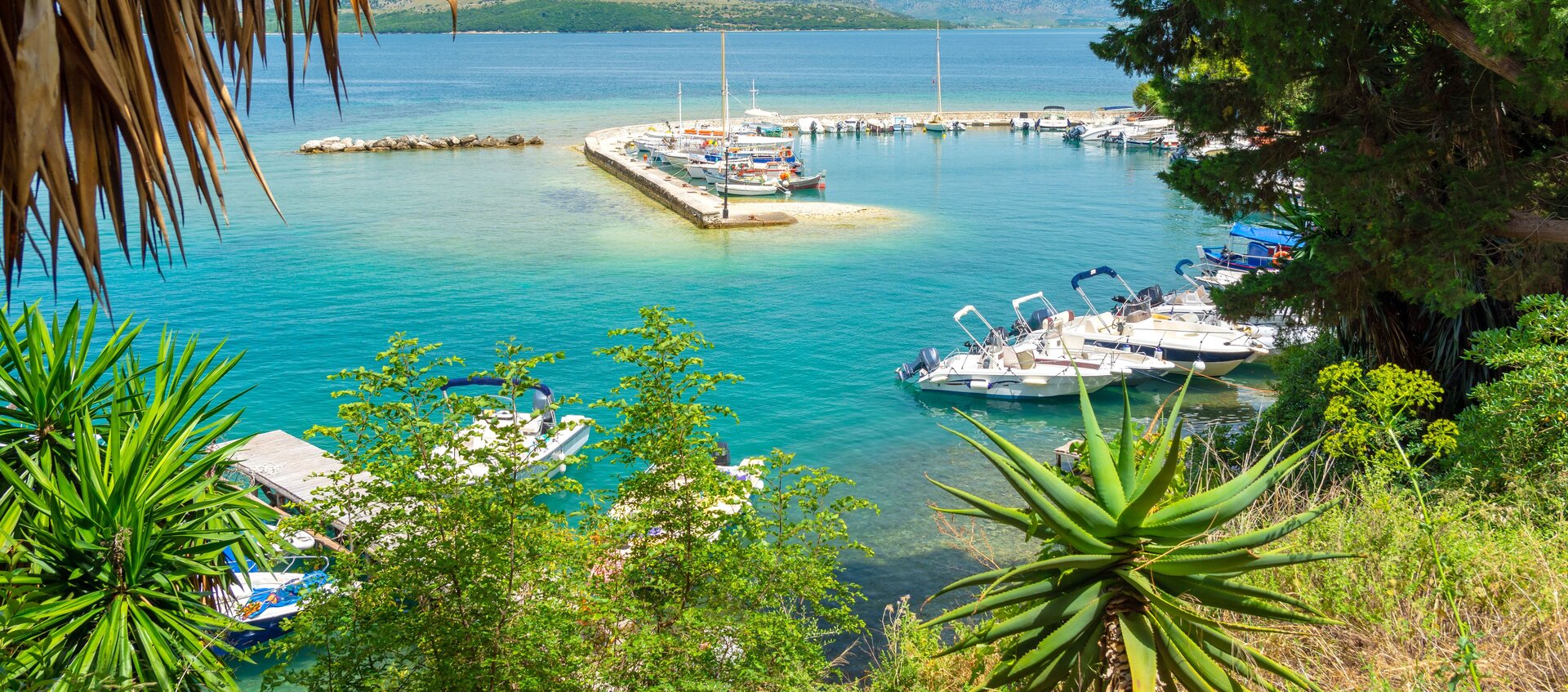 Blick auf den Hafen von Korfu, wo verschiedene Boote am Steg zum Boot mieten Korfu bereitliegen