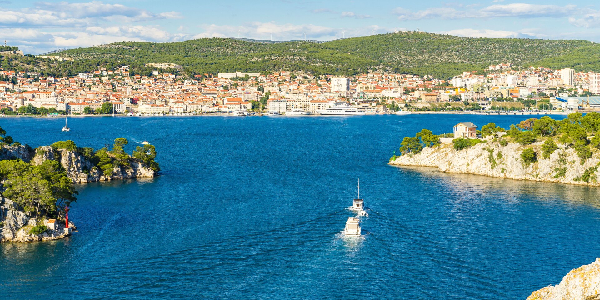 Panorama-Ansicht des Kanals von Sibenik mit zwei Motoryachten vor der Stadtkulisse, ideal zum Motoryacht Charter Sibenik