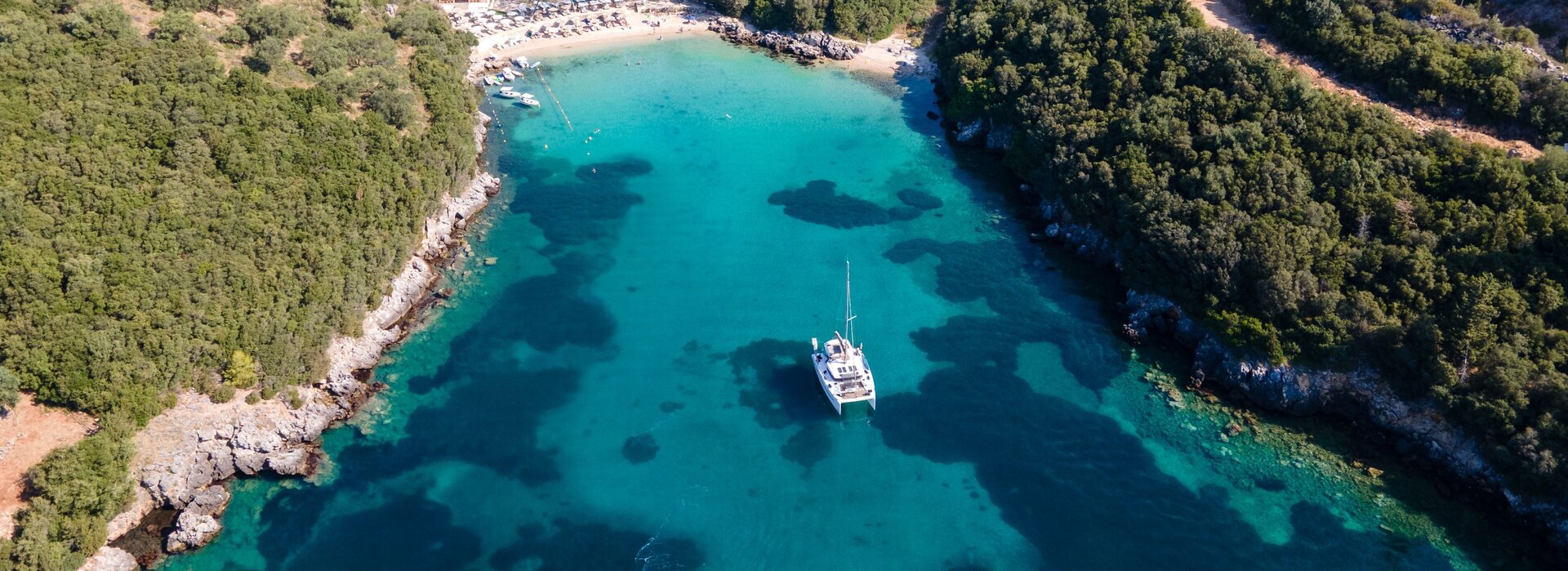 Aerial view of a bay with a chartered catamaran in Athens on turquoise water