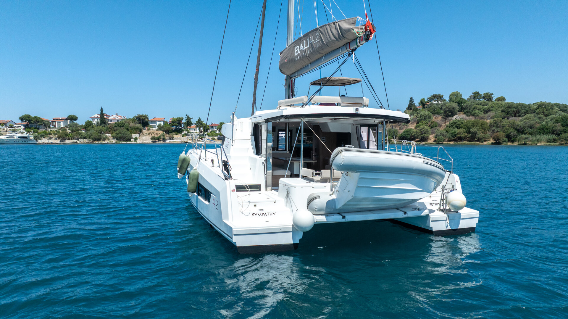 Вид с кормы на современный парусный катамаран Bali 4.2 для аренды катамарана в живописной бухте