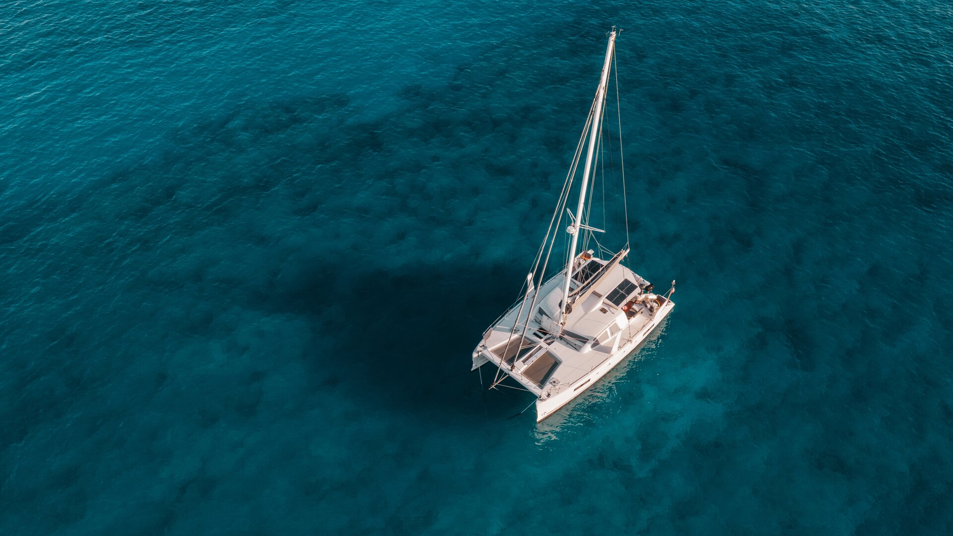 Aerial view of a modern catamaran anchored in turquoise water during a catamaran charter Bodrum