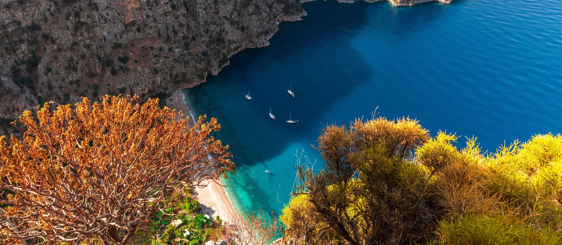 Aerial view of Butterfly Valley with anchored boats for a Fethiye Catamaran charter