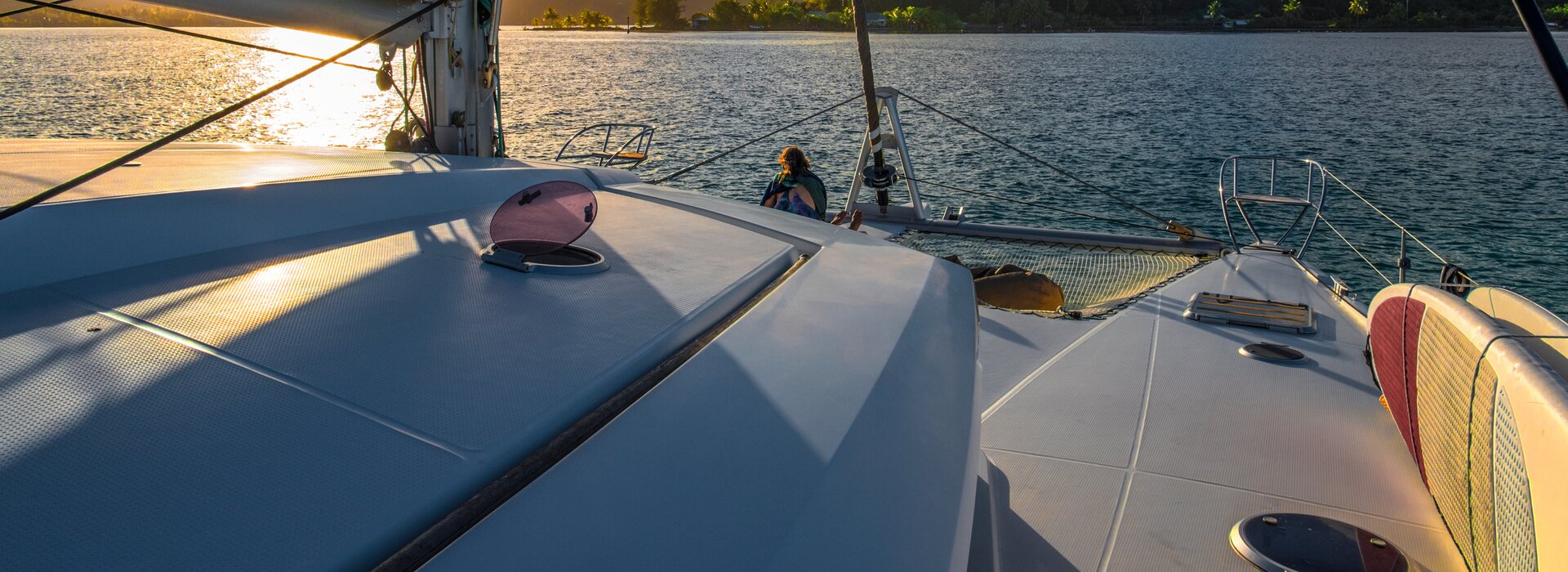 Sonnenuntergang am Bug eines weißen Katamarans, ein Highlight beim Katamaran segeln Italien