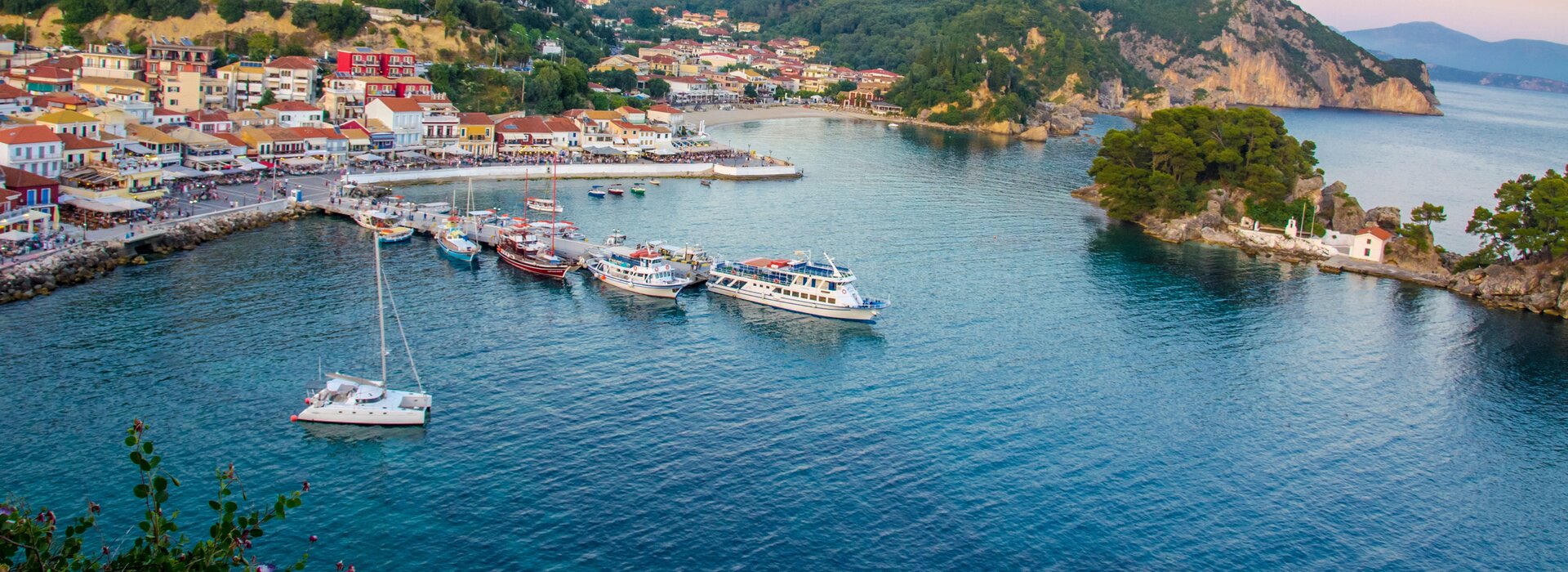 Keyword: Katamaran Charter Preveza Alt-Text: Ein weißer Segler in der Bucht von Parga – ideal für einen Katamaran Chart