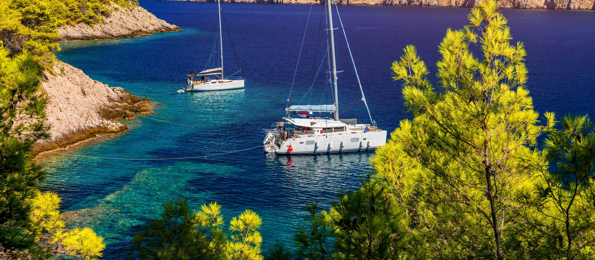 Белоснежный парусный катамаран и аренда катамарана в Турции в тихой бухте с изумрудной водой