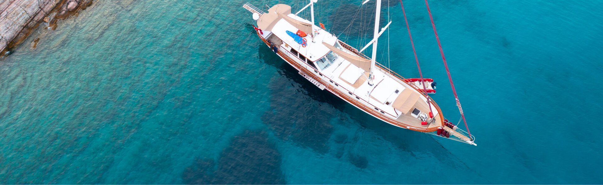 Luftaufnahme einer klassischen Holzgulet beim Gulet Boot mieten in einer türkisfarbenen Bucht