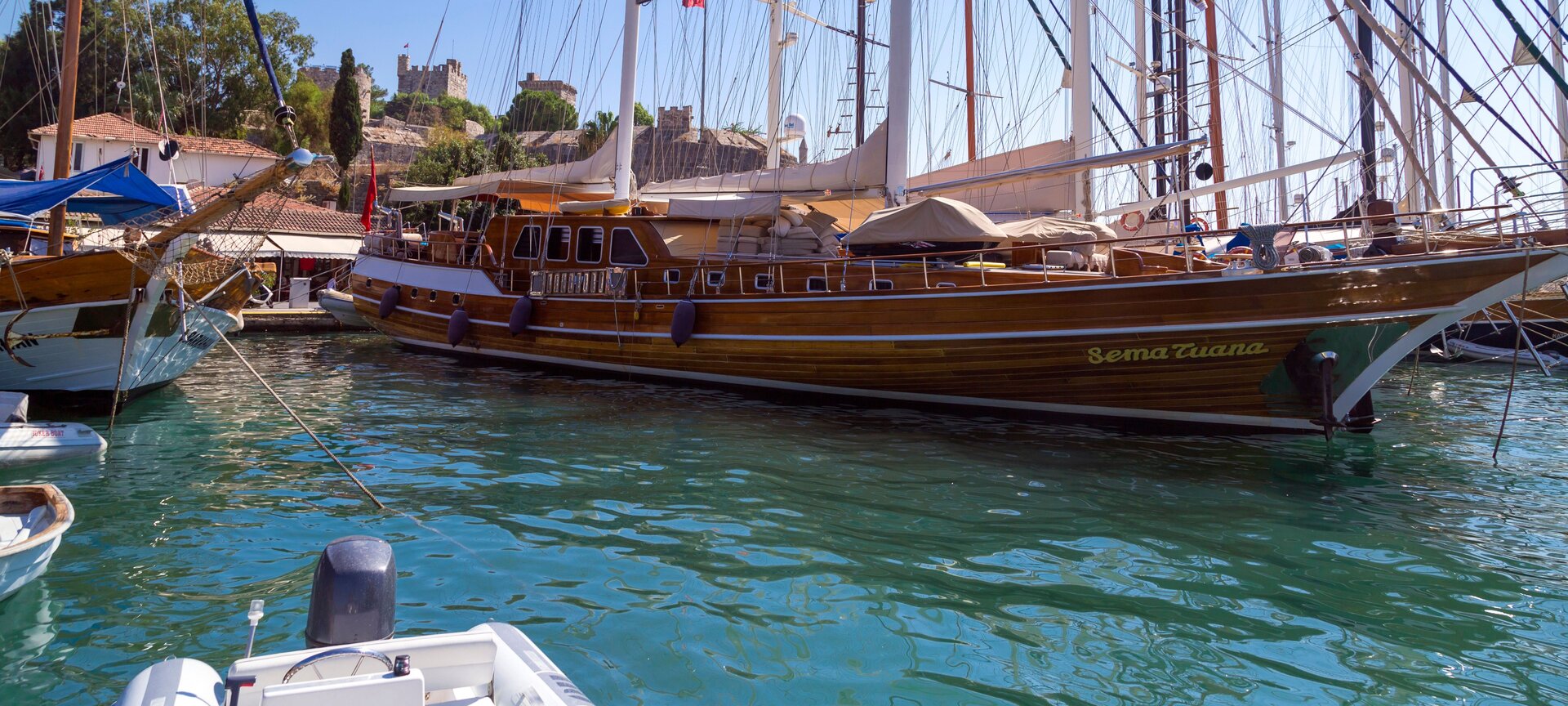 Wooden gulet Sema Tuana moored in the harbour in front of the Bodrum castle, ready for a Gulet rental Bodrum